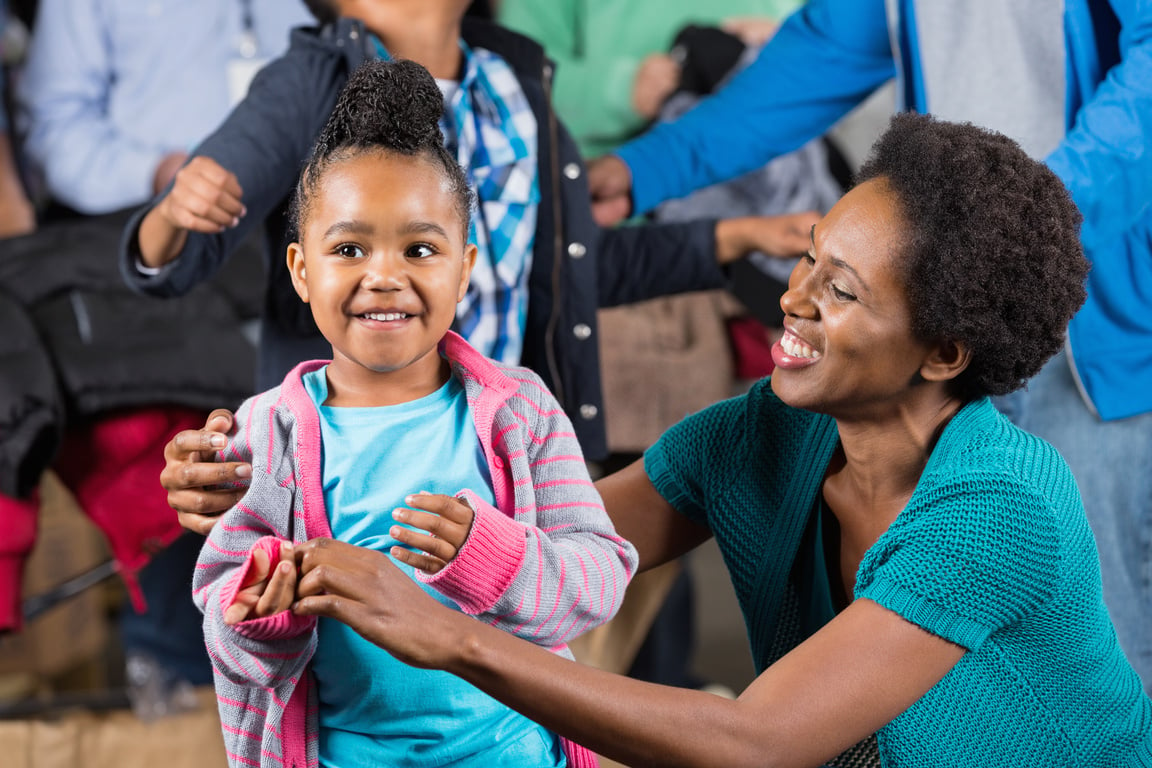 Mother finding donated clothing for kids at winter coat drive